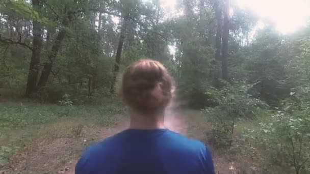 Corre attraverso la foresta. Il tizio sta correndo attraverso la foresta . — Video Stock