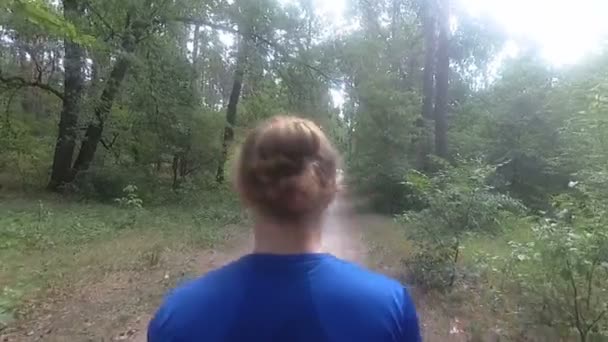 Біжить через ліс. Хлопець біжить лісом . — стокове відео