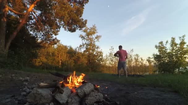 Makkarat paahtaa tulessa metsässä . — kuvapankkivideo