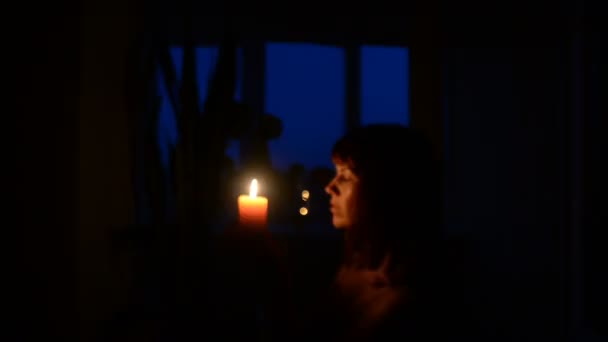 Candle. A girl lights a candle in a dark room — Stock Video