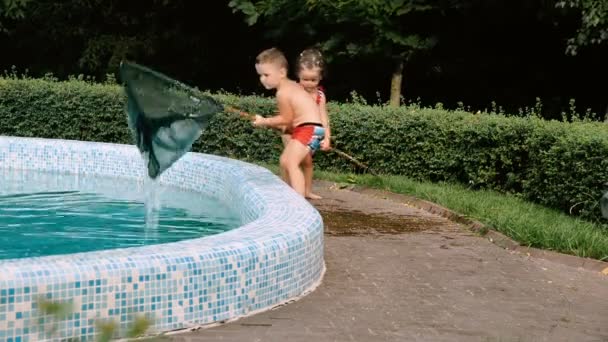 Barn rengör poolen av löv — Stockvideo