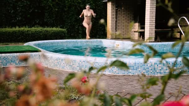 Na piscina. Menina pulando na piscina — Vídeo de Stock