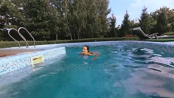 Бассейн. Девушка прыгает в бассейн — стоковое видео