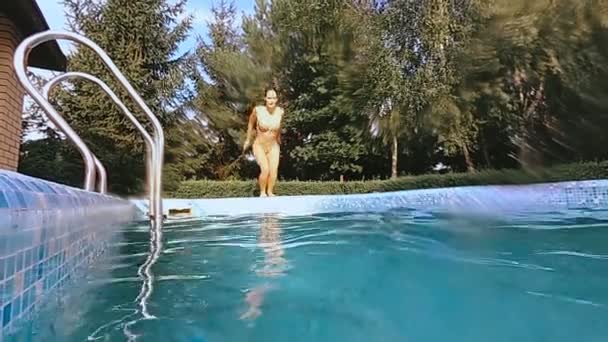 Басейн. Дівчина стрибає в басейн — стокове відео