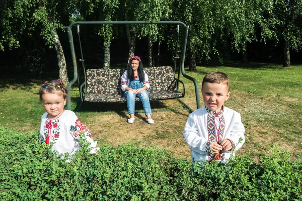 Kinderen met moeder schommel voor een schommel — Stockfoto