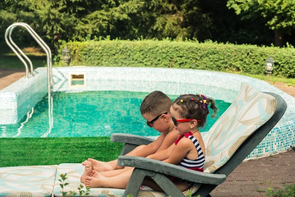 Niños tomando el sol cerca de la piscina — Foto de Stock