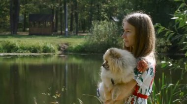 Bir kız ile bir köpek ile bir park yürüme mesafesindedir. Pomeranian Spitz