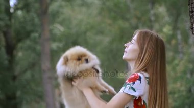 Bir kız ile bir köpek ile bir park yürüme mesafesindedir. Pomeranian Spitz