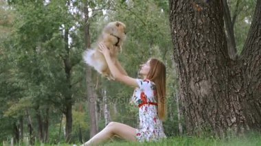 Bir kız ile bir köpek ile bir park yürüme mesafesindedir. Pomeranian Spitz