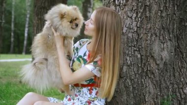 Bir kız ile bir köpek ile bir park yürüme mesafesindedir. Pomeranian Spitz