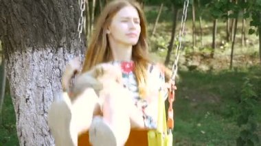 Çocuk swing. Bir kızla bir salıncak üzerinde bir köpek kataetsya.