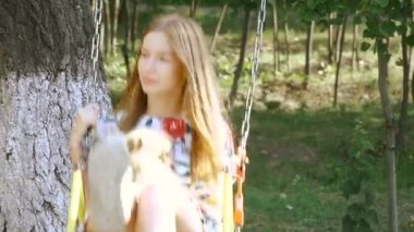 Çocuk swing. Bir kızla bir salıncak üzerinde bir köpek kataetsya.