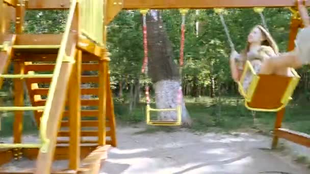 Balanceo infantil. Una chica con un perro kataetsya en un columpio . — Vídeos de Stock