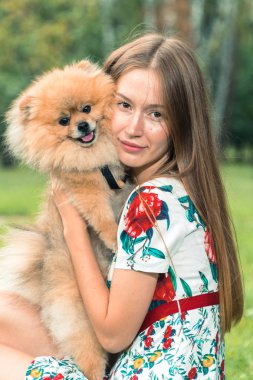 Bir kız ile bir köpek ile bir park yürüme mesafesindedir. Pomeranian Spitz