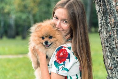 Bir kız ile bir köpek ile bir park yürüme mesafesindedir. Pomeranian Spitz