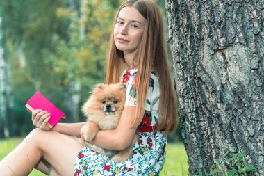 Bir kız ile bir köpek ile bir park yürüme mesafesindedir. Pomeranian Spitz