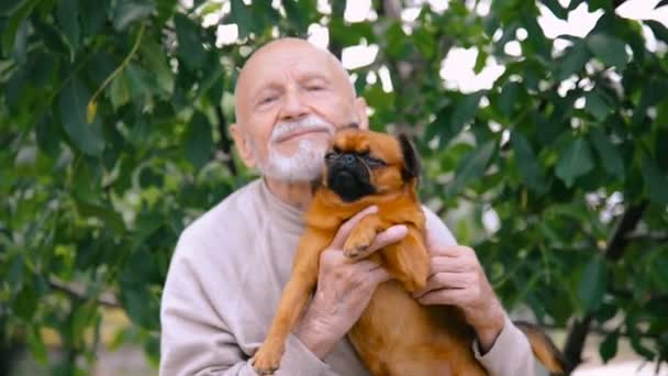 Abuelo con un perro de la raza Griffon — Vídeo de stock