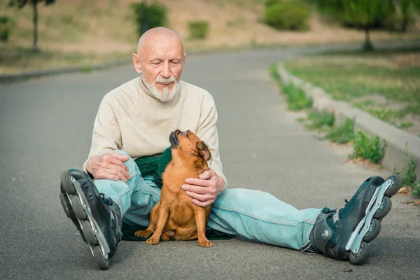 Morfar rullar på rullen med en hund av rasen Griffon — Stockfoto