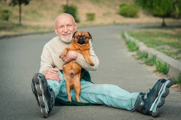 O avô rola no rolo com um cão da raça de Griffon — Fotografia de Stock