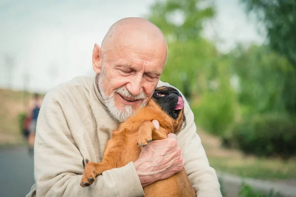 Grandfather with a dog of the Griffon breed — Stock Photo, Image