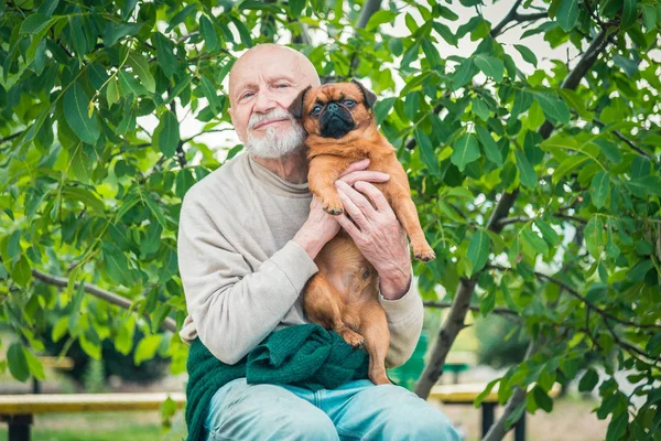 Farfar med en hund av rasen Griffon — Stockfoto