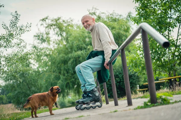 Opa rolt op roller met een hond van het RAS Griffon — Stockfoto