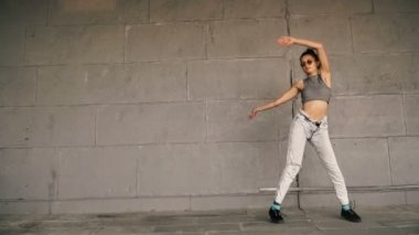 Sıçrama. Kız gri duvara atlama