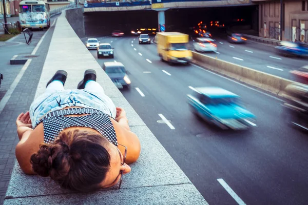 Autoroute. La fille est allongée sur le trottoir près de l'autoroute. — Photo