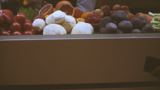 Bänkskiva med frukt. En mänsklig hand väljer en frukt — Stockvideo