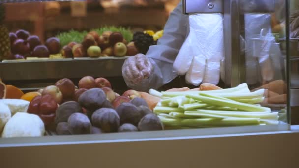 Bancada com fruta. Uma mão humana escolhe um fruto — Vídeo de Stock