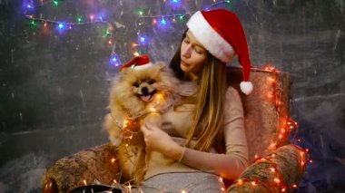 Pomeranian Pomeranian köpek ile Noel şapkalı bir kız