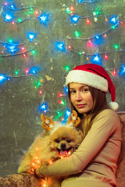 Дівчина в Різдво капелюх з собакою Поморського, Померанський — стокове фото
