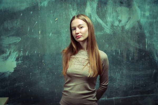 Porträtt. Flicka på en grå vägg bakgrund — Stockfoto