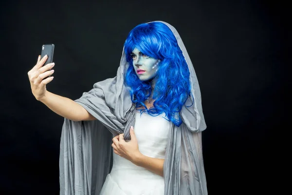 Mobile phone. Girl in makeup makes selfie on mobile phone