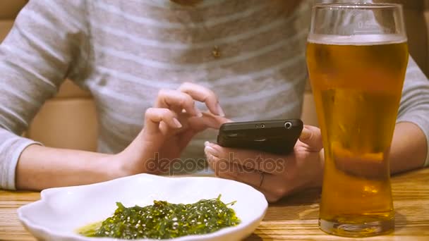 전화입니다 술집에서 여자는 전화의 화면에 보이는 — 비디오