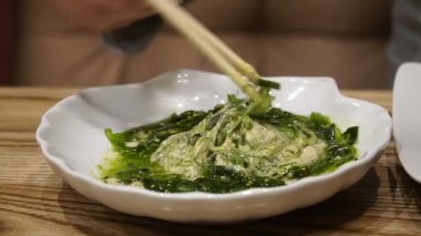 Bir kız bir sushi Bar'da suşi yiyor ve içecekler bira