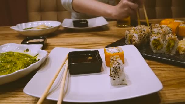 寿司バーで女の子の寿司を食べるし ビールを飲む — ストック動画