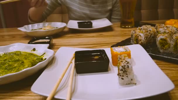 Een Meisje Een Sushibar Sushi Eet Drinkt Bier — Stockvideo