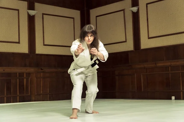 En flicka i en kimono knådar innan träningen i judo och jujutsu — Stockfoto