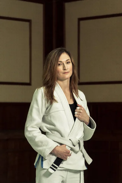 Uma menina em um quimono amassa antes de treinar em judô e jujitsu — Fotografia de Stock