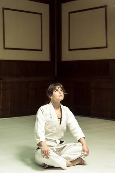 A girl in a kimono kneads before training in judo and jujitsu