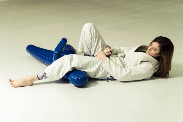 Uma menina em um quimono amassa antes de treinar em judô e jujitsu — Fotografia de Stock