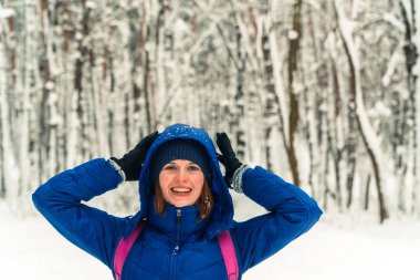Kış. Bir kız bir karla kaplı ormanda yürüyor