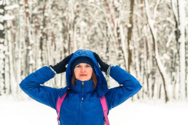 Kış. Bir kız bir karla kaplı ormanda yürüyor