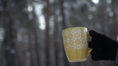 Sıcak kahve kış ormanın içinde. Kahve içme kız