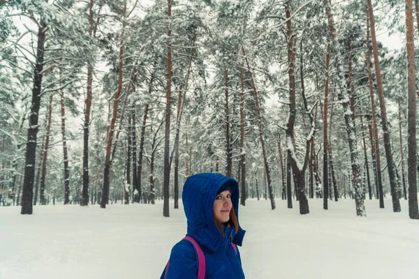El invierno. Una chica está caminando en un bosque nevado — Foto de Stock