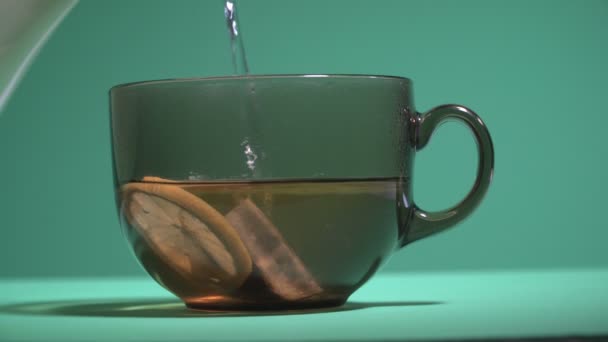 Du thé. La tasse est remplie d'eau bouillante avec du citron et des feuilles de thé 