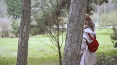 Kedi bir leash üzerinde. Bir kız omuzunda oturur bir kedi ile yürüyor