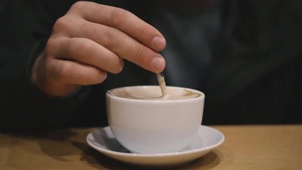 カプチーノハンドスプーンはカプチーノのカップに砂糖を攪拌 — ストック動画