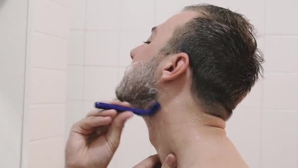 可处置剃须刀 那家伙在浴室里用一次性剃须刀刮胡子 — 图库视频影像